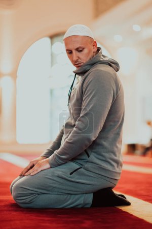 Foto de Un musulmán rezando en una mezquita moderna durante el sagrado mes musulmán de Ramadán. - Imagen libre de derechos