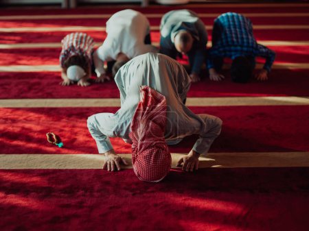 Foto de Un grupo de musulmanes en una mezquita moderna rezando la oración musulmana namaz, durante el mes sagrado del Ramadán. - Imagen libre de derechos