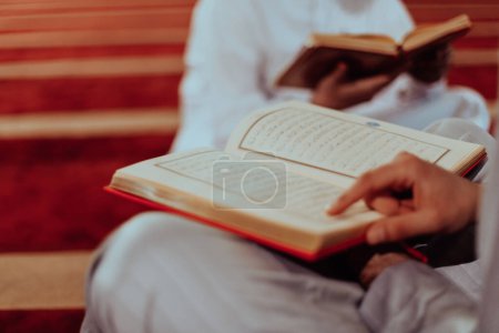 A group of Muslims reading the holy book of the Quran in a modern mosque during the Muslim holiday of Ramadan. 