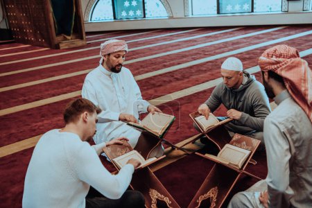 Photo for A group of Muslims reading the holy book of the Quran in a modern mosque during the Muslim holiday of Ramadan. - Royalty Free Image