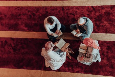 Foto de Un grupo de musulmanes leyendo el libro sagrado del Corán en una mezquita moderna durante la fiesta musulmana del Ramadán. - Imagen libre de derechos