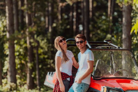 Foto de Young happy excited couple enjoying beautiful sunny day while driving a off road buggy car on mountain nature. - Imagen libre de derechos