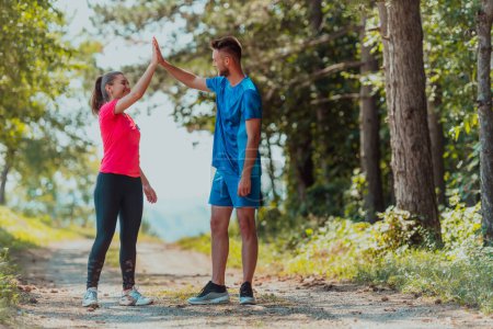 Photo for Couple enjoying in a healthy lifestyle while jogging on a country road. - Royalty Free Image
