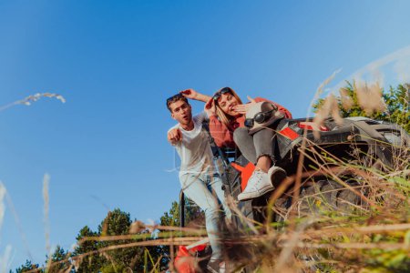 Photo for Young happy excited couple enjoying beautiful sunny day while driving a off road buggy car on mountain nature. - Royalty Free Image