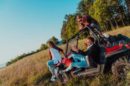 Foto de Group young happy people enjoying beautiful sunny day while driving a off road buggy car on mountain nature. - Imagen libre de derechos