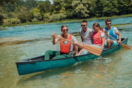 Téléchargez les photos : Groupe d'amis explorateurs aventureux font du canoë dans une rivière sauvage. - en image libre de droit