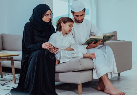 Téléchargez les photos : Happy Muslim family enjoying the holy month of Ramadan while praying and reading the Quran together in a modern home. - en image libre de droit
