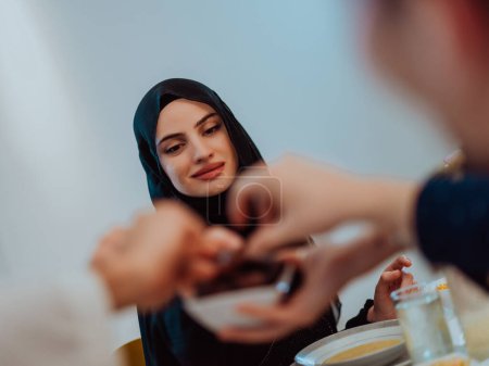 Téléchargez les photos : Famille musulmane multiethnique moderne partageant un bol de dates tout en profitant iftar dîner ensemble lors d'un festin de ramadan à la maison
. - en image libre de droit