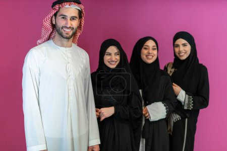 Foto de Group portrait of young Muslim people Arabian men with three Muslim women in a fashionable dress with hijab isolated on a pink background. - Imagen libre de derechos