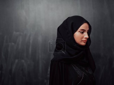 Téléchargez les photos : Portrait de belle femme musulmane en robe à la mode avec hijab devant un tableau noir représentant la mode islam moderne et le concept de Ramadan Kareem
. - en image libre de droit