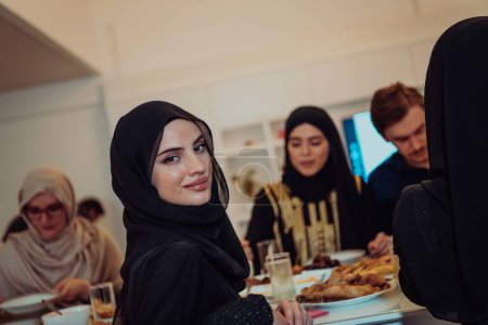 Téléchargez les photos : Eid Mubarak Muslim family having Iftar dinner taking pictures with smartphone while eating traditional food during Ramadan feasting month at home. The Islamic Halal Eating and Drinking Islamic family - en image libre de droit