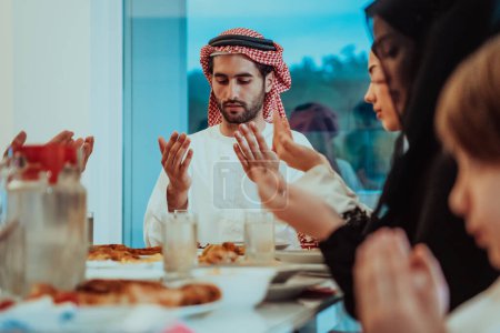 Photo for A Muslim family praying together, the Muslim prayer after breaking the fast in the Islamic holy month of Ramadan. - Royalty Free Image