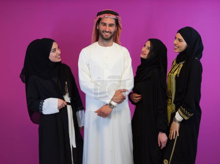 Téléchargez les photos : Portrait de groupe de jeunes musulmans homme arabe avec trois femmes musulmanes en robe à la mode avec hijab isolé sur fond rose représentant la mode islam moderne et concept de Ramadan Kareem
. - en image libre de droit