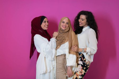 Foto de Retrato de grupo de hermosas mujeres musulmanas dos de ellos en vestido de moda con hijab aislado sobre fondo rosa que representa la moda islam moderna y el concepto de kareem ramadán
. - Imagen libre de derechos