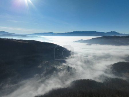 Téléchargez les photos : Aerial View. Flying over the high mountains in beautiful clouds. Aerial Drone camera shot. Air pollution clouds over Sarajevo in Bosnia and Herzegovina. Hi quality 4K footage. - en image libre de droit
