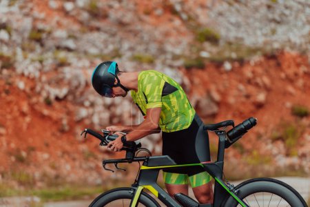 Téléchargez les photos : Un triathlète professionnel se préparant pour une promenade d'entraînement sur un vélo. - en image libre de droit