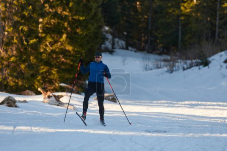 Foto de Esquí nórdico o esquí de fondo técnica clásica practicada por el hombre en un hermoso sendero panorámico por la mañana. Enfoque selectivo - Imagen libre de derechos