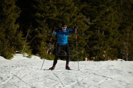 Foto de Nordic skiing or Cross-country skiing classic technique practiced by man in a beautiful panoramic trail at morning. Selective focus - Imagen libre de derechos