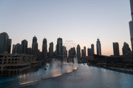 Foto de Dubai cantando fuentes en vista al lago nocturno entre rascacielos. Ciudad horizonte en la arquitectura moderna del atardecer en la capital de los Emiratos Árabes Unidos centro. Imágenes de alta calidad 4k - Imagen libre de derechos