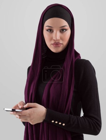 Téléchargez les photos : Woman in black stylish fashionable clothes Muslim headscarf. Lady using smart phone, close up portrait of smiling middle eastern girl. High quality photo - en image libre de droit