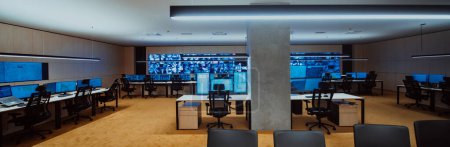 Foto de Empty interior of big modern security system control room, workstation with multiple displays, monitoring room with at security data center Empty office, desk, and chairs at a main CCTV security data - Imagen libre de derechos