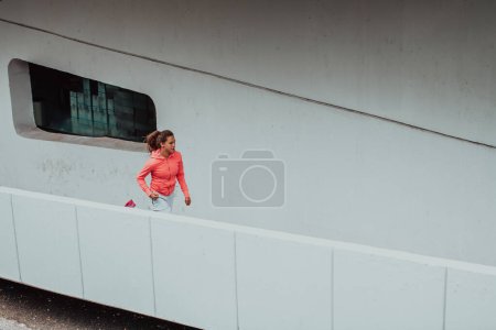 Photo for Women in sports clothes running in a modern urban environment. The concept of a sporty and healthy lifestyle. - Royalty Free Image