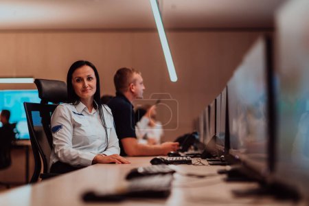 Photo for Group of Security data center operators working in a CCTV monitoring room looking on multiple monitors.Officers Monitoring Multiple Screens for Suspicious Activities. - Royalty Free Image