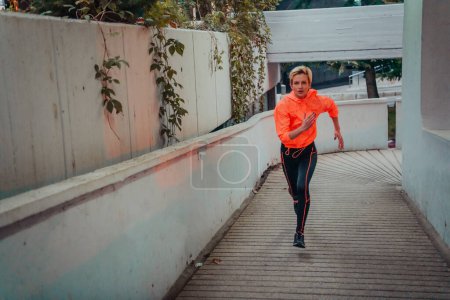 Téléchargez les photos : Women in sports clothes running in a modern urban environment et night time. The concept of a sporty and healthy lifestyle. - en image libre de droit