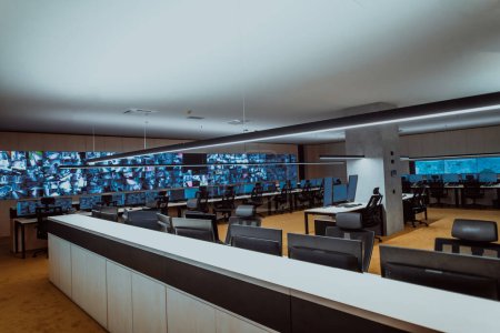 Foto de Empty interior of big modern security system control room, workstation with multiple displays, monitoring room with at security data center Empty office, desk, and chairs at a main CCTV security data - Imagen libre de derechos