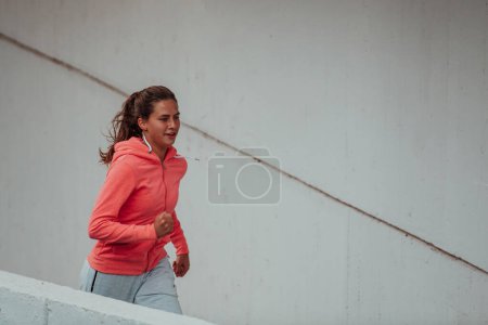 Photo for Women in sports clothes running in a modern urban environment. The concept of a sporty and healthy lifestyle. - Royalty Free Image