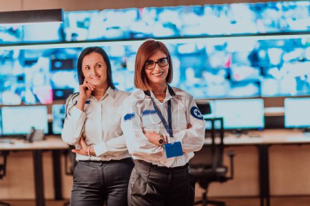 Foto de Group portrait of female security operator while working in a data system control room offices Technical Operator Working at workstation with multiple displays. - Imagen libre de derechos