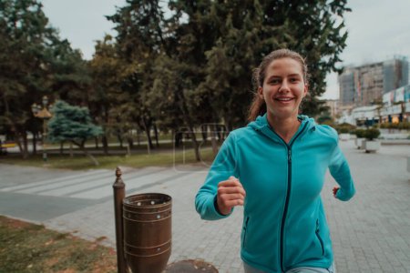 Foto de Women in sports clothes running in a modern urban environment. The concept of a sporty and healthy lifestyle. - Imagen libre de derechos
