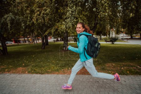 Téléchargez les photos : Women in sports clothes running in a modern urban environment. The concept of a sporty and healthy lifestyle. - en image libre de droit