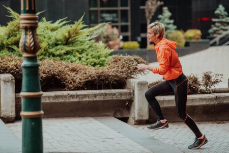 Foto de Una rubia con un atuendo deportivo recorre la ciudad en un entorno urbano. La rubia caliente mantiene un estilo de vida saludable - Imagen libre de derechos