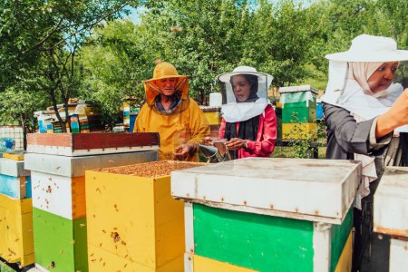 Foto de Inversores árabes controlan la calidad de la miel en una gran granja de abejas en la que han invertido su dinero. Concepto de inversión en pequeñas empresas. - Imagen libre de derechos