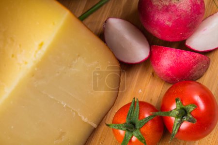 Photo for Bosnian traditional cheese served on a wooden container with peppers, parade and onions isolated on a white background. - Royalty Free Image