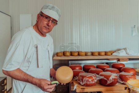 Téléchargez les photos : Cheese maker working in the industry for manual production of homemade cheese. - en image libre de droit