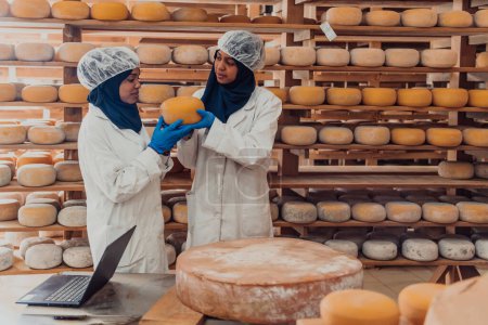 Photo for Muslim business partners check the quality of cheese in the modern industry. - Royalty Free Image