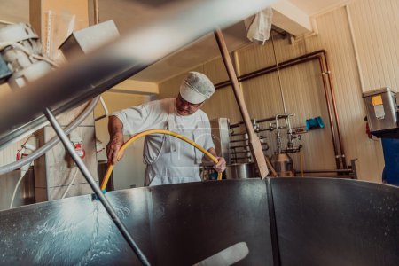 Foto de A cheese makser working in the industry on various machines with the help of which cheese is processed. Small business concept. - Imagen libre de derechos