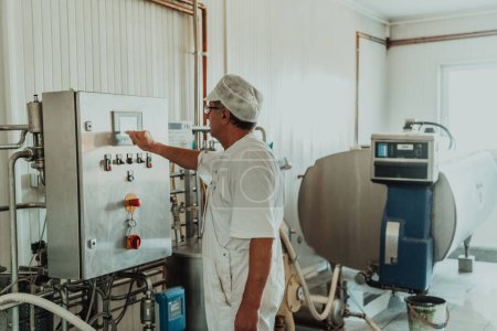 Téléchargez les photos : Cheese maker working in the modern industry on machines that are using for the machining of fresh cheese. - en image libre de droit