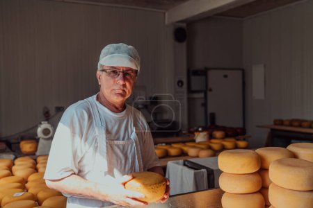 Foto de The cheese maker sorting freshly processed pieces of cheese and preparing them for the further processing process. - Imagen libre de derechos