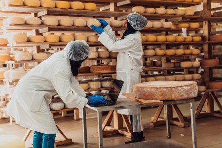 Foto de Socios comerciales musulmanes comprueban la calidad del queso en la industria moderna. - Imagen libre de derechos