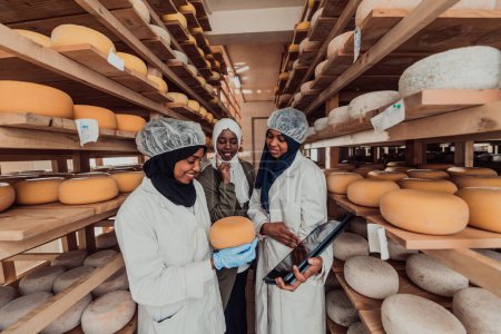 Foto de Arab business partners checking the quality of cheese in the industry and enter data into a laptop. Small business concept. - Imagen libre de derechos