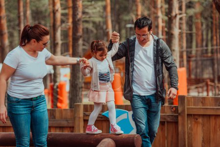Foto de Family fun in the park. Happy family spending time in park and playing with their daughter. - Imagen libre de derechos