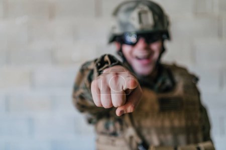 Photo for I choose you. A soldier with an outstretched hand towards the camera shows that he chooses you for support and partnership in warfare. - Royalty Free Image