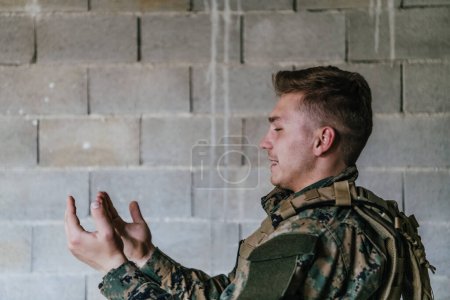 Foto de Un soldado musulmán de las fuerzas especiales ora a Dios levantando las manos y comienza una oración. - Imagen libre de derechos