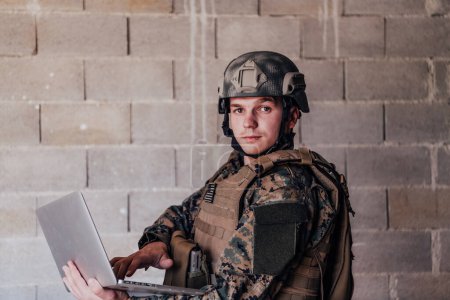 Photo for American soldier in military uniform using laptop computer for drone controlling and to stay in contact with friends and family. - Royalty Free Image