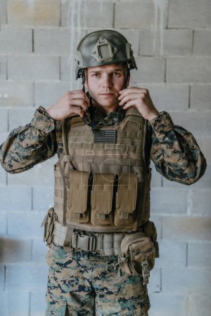 Téléchargez les photos : Soldat préparant l'équipement tactique de protection et de communication pour la bataille d'action. - en image libre de droit