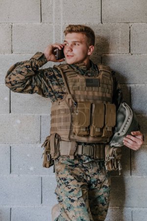Téléchargez les photos : Soldat utilisant un smartphone et appelant la famille et les franges à la maison. - en image libre de droit