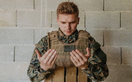 Téléchargez les photos : Un soldat musulman des forces spéciales prie Dieu en levant la main et commence une prière. - en image libre de droit